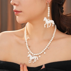 Close-up of pearl necklace and horse pendant worn by model for an elegant aesthetic