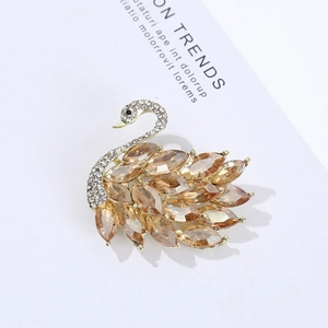 Elegant gold swan brooch with champagne crystals and sparkling rhinestones on white