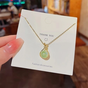 Minimalist gold titanium necklace with green round jade pendant and sparkling rhinestones