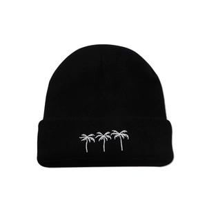 Close-up detail of three white embroidered coconut trees on a black knitted beanie