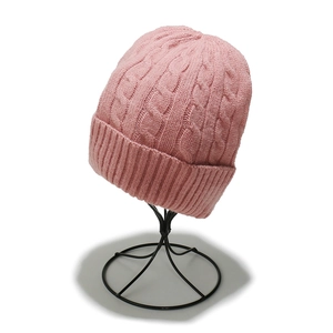 Detailed close-up of pink cable knit beanie with thick ribbed cuff and soft texture