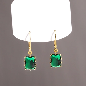 Détails des boucles d'oreilles dorées avec zircons rectangulaires vert émeraude