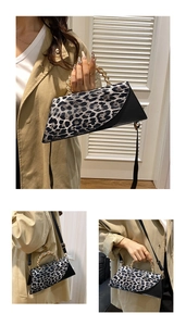 Detail view of leopard print handbag with gold chain handle and black crossbody strap