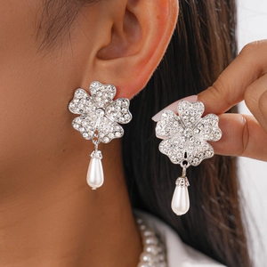 Close-up of baroque silver flower earrings with sparkling crystals and pearl drop