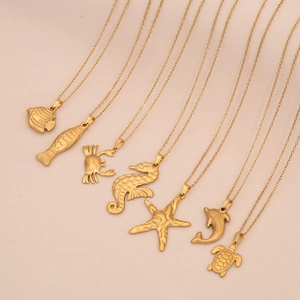 Detailansicht goldener Meeres-Halsketten mit Seestern-, Schildkröten- und Seepferdchen-Anhängern