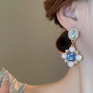 Vue détaillée de boucles d'oreilles vintage avec camée et pierres violettes polies