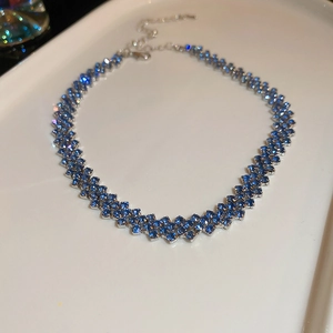 Dettaglio macro del girocollo argento multifila con cristalli blu scuro su vassoio