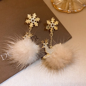 Detail of Christmas snowflake earrings with deer charm and beige plush pompom