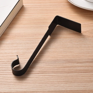 Detail of a minimalist black metal fireplace mantel hook for hanging Christmas stockings