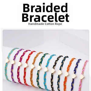 Macro shot of colorful handmade braided friendship bracelets with gold heart charms