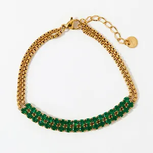 Detail of double-row gold-plated bracelet featuring square-cut green gemstones