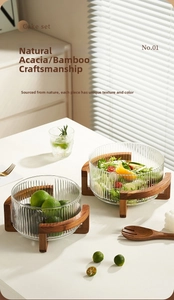 Vertical fluted glass salad bowls with natural acacia wood stand in home setting