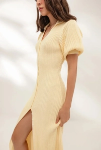 Detail of light yellow knit polo dress showing puff sleeves and vertical ribbed texture