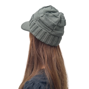 Gros plan du bonnet tricoté gris foncé à visière avec texture à rayures et à carreaux