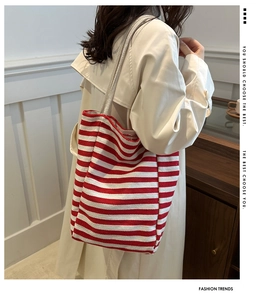 Detail of red and white striped canvas tote bag showing the woven fabric texture and size