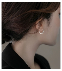 Close-up of S925 sterling silver daisy hoop earrings with textured finish on model