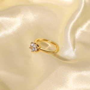 Adjustable 18K gold plated ring with round clear zircon stone on beige satin fabric