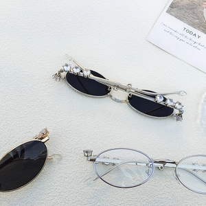 Detailed view of oval rhinestone-encrusted metal glasses in gold and black lenses