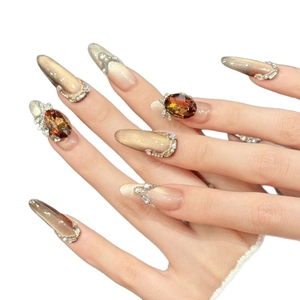 Brown cat-eye press-on nails with amber gemstones and sparkling diamonds on almond shape