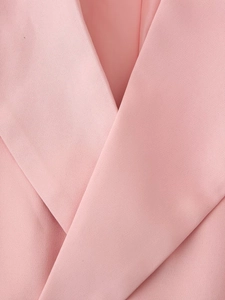 Close-up of pink blazer lapel detail showing high-quality woven fabric texture