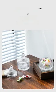 Detail of ribbed glass candy jar with sphere handle lid on dark wooden surface