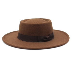 Detail of a dark brown wool felt fedora with a grosgrain ribbon and bow decoration