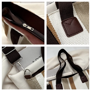 Detail view of striped canvas tote bag showing metal hooks and reinforced stitching