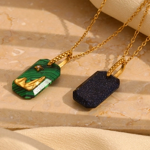 Detailed close-up of 18K gold plated necklaces with green malachite and blue starstone charms