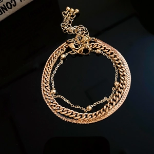 Detailed view of layered gold chunky Cuban and snake chains with polished lobster clasp