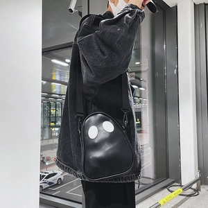 Lifestyle shot of a black cartoon ghost crossbody bag worn over the shoulder in street style