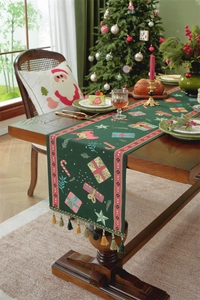 Close-up of green Christmas table runner with festive jacquard patterns and tassel detail
