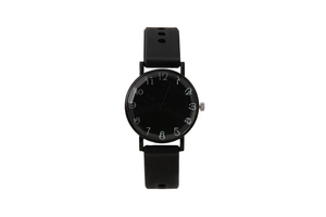 Detailed close-up of a minimalist black quartz watch with hand-drawn white Arabic numerals