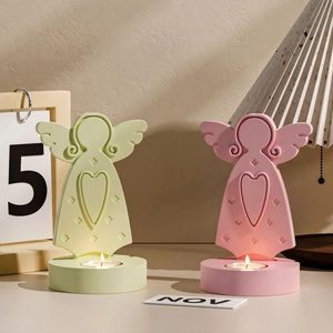 Detail of angel wing candle holders with heart cutout and flickering tea light candles