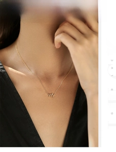 Gros plan du collier avec pendentif chiffre 777 doré et petit diamant sur le cou d'une femme