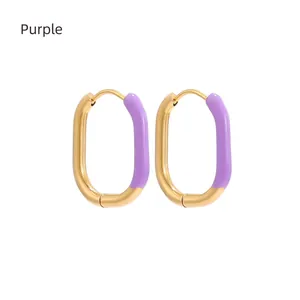 Detailed macro view of U-shaped gold plated earrings with purple enamel drip oil finish