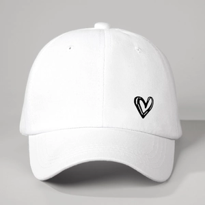 Classic white cotton baseball cap with black heart embroidery in a 45-degree angle view