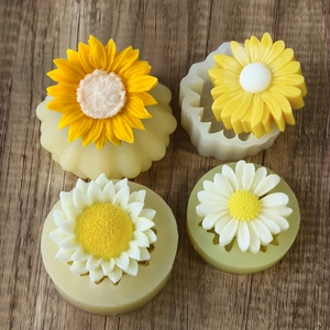 Sunflower and daisy silicone molds for DIY candles and soaps on a wooden surface
