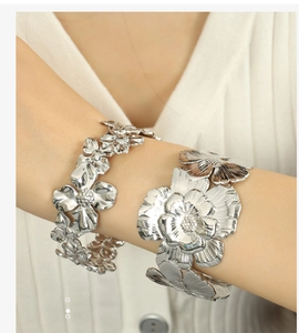 Detail of silver titanium camellia flower bangles featuring intricate layered petal design
