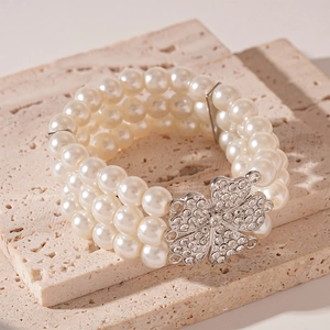 Detail of multi-layer pearl bracelet with rhinestone flower clasp on stone base