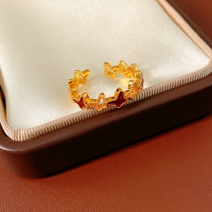 Close-up of 18k gold plated open ring with red enamel butterfly design elements