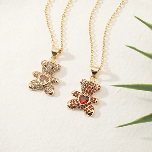 Sparkling copper micro-paved bear necklace with heart-shaped champagne and red gems