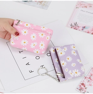 Detailed close-up of pink and purple daisy print coin purses with zipper and key ring