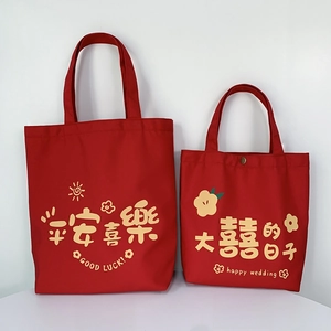 Detailed comparison of large and small red canvas wedding gift bags with festive text