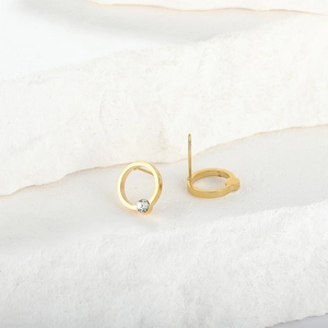 Chic gold-plated stainless steel hoop earrings with sparkling zircon on stone background