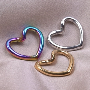 Macro shot of gold, silver and rainbow heart-shaped stainless steel jewelry connectors