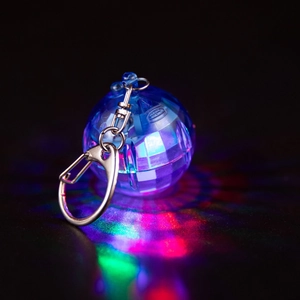 Macro view of blue glowing disco ball keychain with colorful LED light and silver clasp