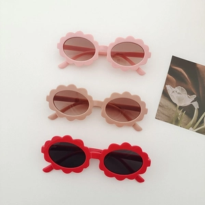 Close-up of kids flower shaped sunglasses in pink, light brown and bright red colors