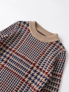 Detailed view of the houndstooth knit sweater featuring ribbed neckline and autumn colors
