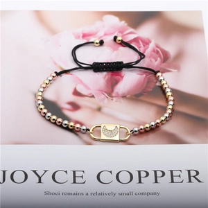 Macro shot of tricolor copper beads and micro-pave zircon crescent moon charm on black cord