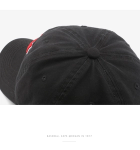 Detail of black cotton baseball cap showing 6-panel stitching and premium embroidery